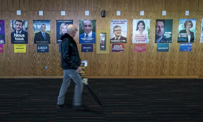 Французский избиратель проходит мимо фотографий для голосования в первом туре президентских выборов во Франции 2022 года в Монреале, 9 апреля 2022 года. (Peter McCabe/The Canadian Press via AP)
 | Epoch Times Media
