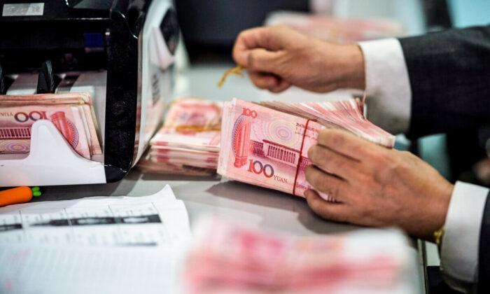 Сотрудник банка отсчитывает юани в банке Шанхая. Китай, 8 августа 2018 года. Изображение: Johannes Eisele/AFP via Getty Images | Epoch Times Media