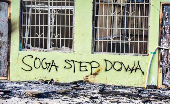 Антиправительственные послания украшают сгоревшее здание в Хониаре, Соломоновы острова, 27 ноября 2021 года, (CharleyPiringi/AFP viaGettyImages)