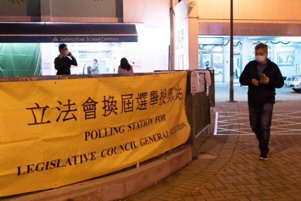 Избиратель покидает избирательный участок во время выборов в Законодательный совет в районе Чой Хун в Гонконге 19 декабря 2021 года. (Bertha Wang/AFP via Getty Images)
