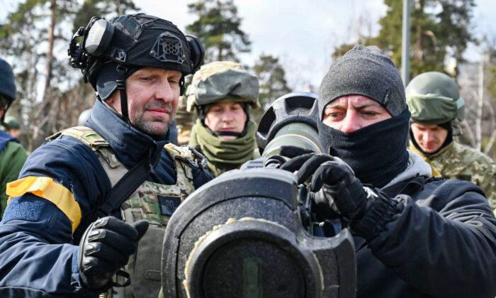 Военнослужащие сил территориальной обороны Украины осматривают новое вооружение, включая противотанковые системы NLAW и другие переносные противотанковые гранатомёты, в Киеве, Украина, 9 марта 2022 года. (Genya Savilov/AFP/Getty Images)