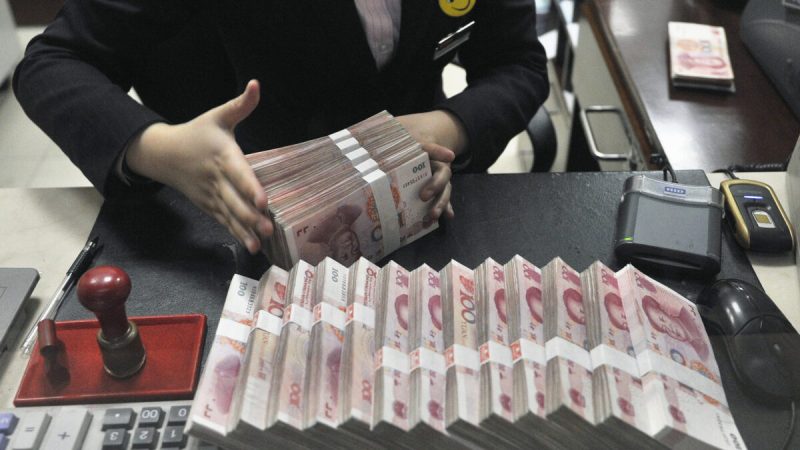 Пачки банкнот номиналом 100 китайских юаней в отделении China Merchants Bank в Хэфэй, провинция Аньхой, 17 марта 2014 года. (Фото: Reuters)
 | Epoch Times Media