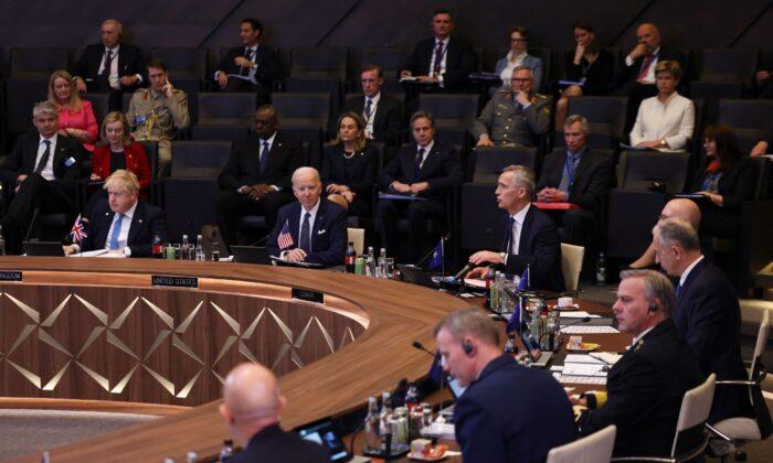 Премьер-министр Великобритании Борис Джонсон и президент Джо Байден слушают выступление генерального секретаря НАТО Йенса Столтенберга на заседании Североатлантического совета во время внеочередного саммита в штаб-квартире НАТО в Брюсселе 24 марта 2022 года. Фото: Evelyn Hockstein/Pool/AFP via Getty Images
 | Epoch Times Media
