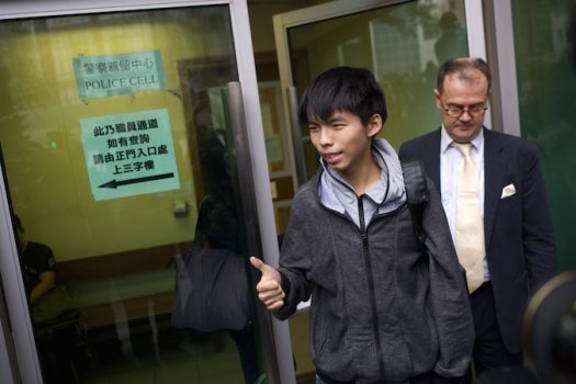 Студенческий лидер Джошуа Вонг (слева) выходит из здания суда со своим адвокатом Майклом Видлером (справа) после освобождения его под залог в Гонконге 27 ноября 2014 года. (Aaron Tam/AFP/Getty Images)