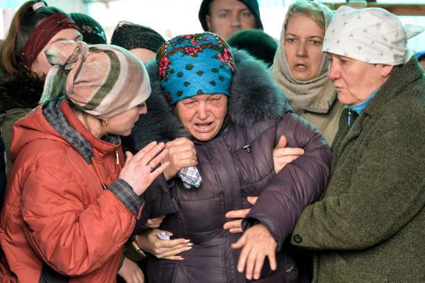 Мать Любовь Зарифилина и родственники на похоронах Рустама Зарифулина, 26 лет, погибшего 14 марта во время российского вторжения в Украину в городе Кара-Балта примерно в 60 км от Бишкека, 27 марта 2022 года. Фото: VYACHESLAV OSELEDKO/AFP via Getty Images