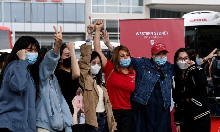 Иностранные студенты с представителями университета после прибытия в аэропорт в Сиднее, Австралия, 6 декабря 2021 года.(AAP Image/Bianca De Marchi)
 | Epoch Times Media
