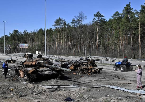 Сгоревший российский танк и автомобиль недалеко от села Богдановка к северо-востоку от Киева, 7 апреля 2022 года. Фото GENYA SAVILOV / AFP via Getty Images | Epoch Times Media