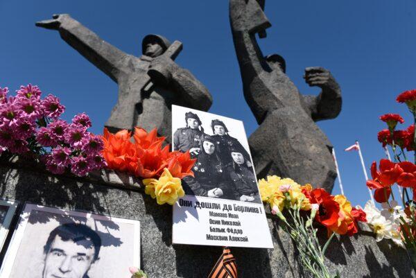 Представители многочисленного русского меньшинства Латвии возлагают фотографии солдат и цветы к памятнику Победы в 73 годовщину со дня окончания Второй мировой войны, Рига, Латвия, 9 мая 2018 года. (ILMARS ZNOTINS/AFP via Getty Images)