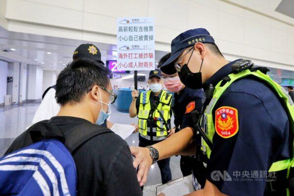 Полицейские в международном аэропорту Таоюань в рамках правительственной кампании по борьбе с торговлей людьми уговаривают пассажира не садиться на рейс в Камбоджу, 1 августа 2022 года. (Courtesy of CNA)