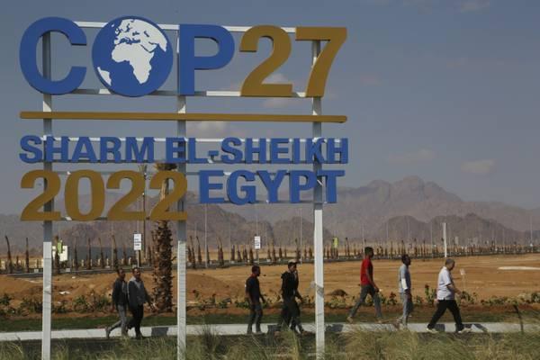 Рабочие проходят мимо плаката, рекламирующего глобальный саммит COP27 Организации Объединённых Наций по изменению климата и украшающего Дорогу мира в Шарм-эль-Шейхе, Южный Синай, Египет. (AP Photo) | Epoch Times Media
