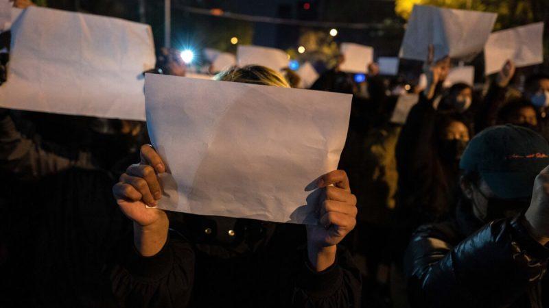 Протестующие держат белый лист бумаги во время марша протеста против строгих мер Китая по борьбе с COVID в Пекине 27 ноября 2022 года. (Kevin Frayer/Getty Images) | Epoch Times Media