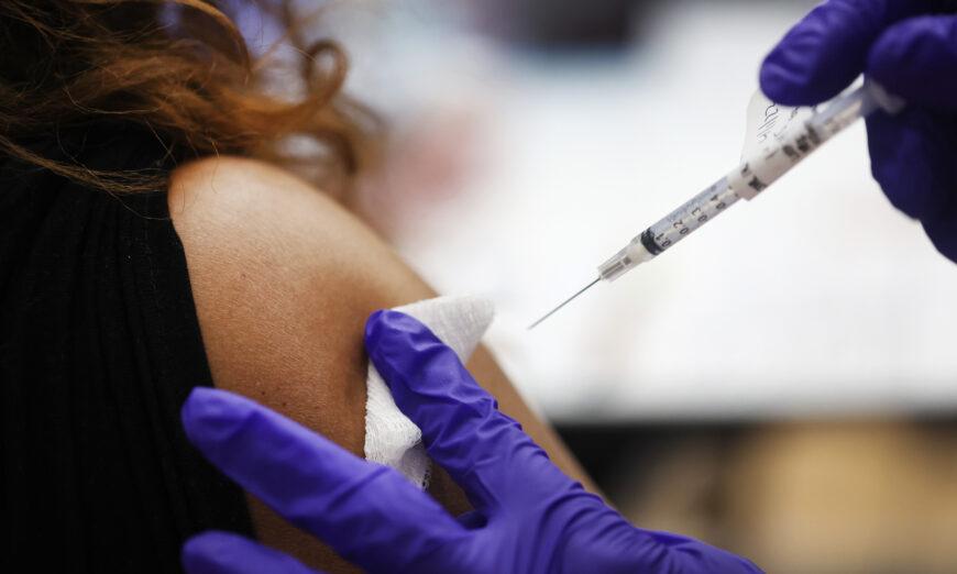 Медсестра вводит бустерную дозу вакцины против COVID-19 человеку в больнице в Хайнсе, штат Иллинойс, 1 апреля 2022 года. (Scott Olson/Getty Images)