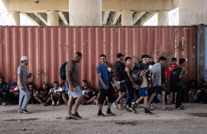 Нелегальные иммигранты ждут досмотра пограничным патрулём США в процессинговом центре под мостом в Игл-Пасс, штат Техас, 25 сентября 2023 года. (Andrew Caballero-Reynolds/AFP via Getty Images)